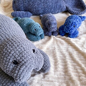 Puede incluir: Cuatro peluches de manat&iacute; de crochet en diferentes tama&ntilde;os y colores. El manat&iacute; m&aacute;s grande es gris, el siguiente m&aacute;s grande es verde azulado y los dos m&aacute;s peque&ntilde;os son azules.