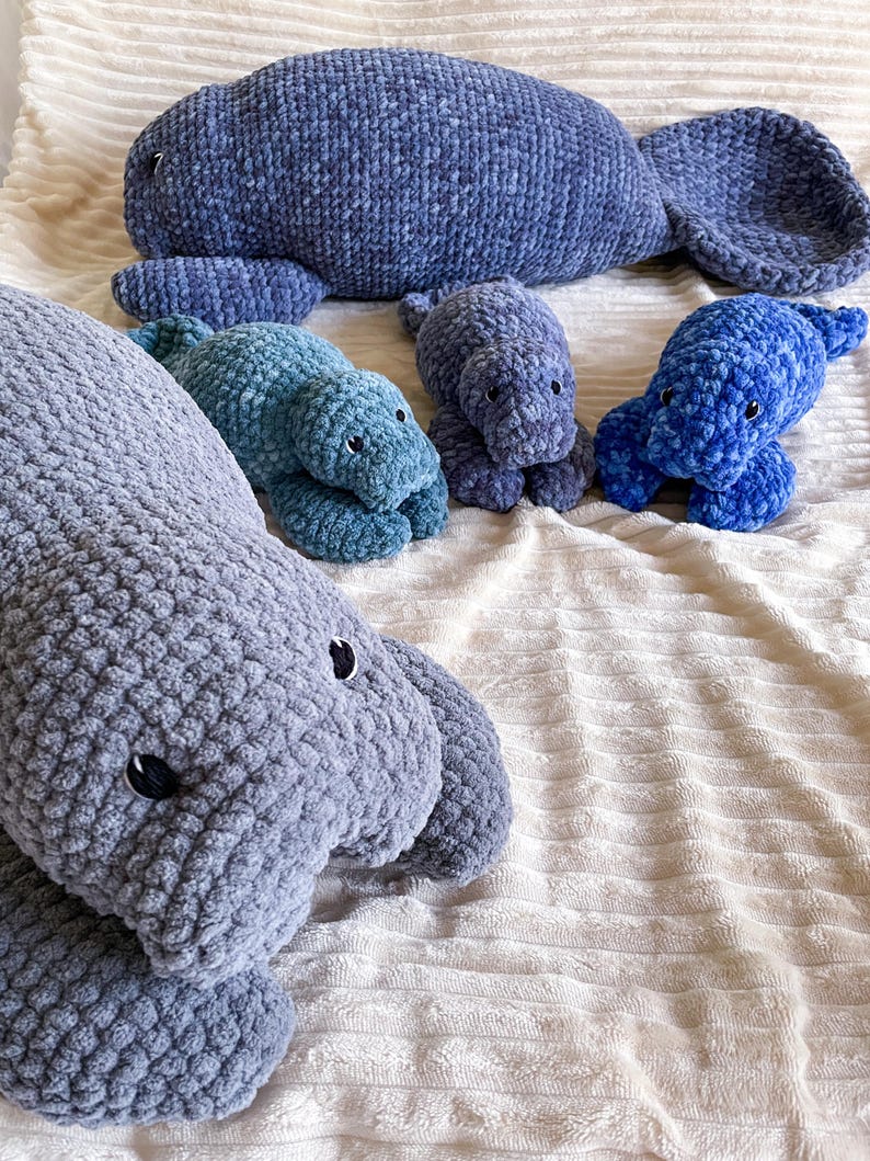 Puede incluir: Cuatro peluches de manat&iacute; de crochet en diferentes tama&ntilde;os y colores. El manat&iacute; m&aacute;s grande es gris, el siguiente m&aacute;s grande es verde azulado y los dos m&aacute;s peque&ntilde;os son azules.