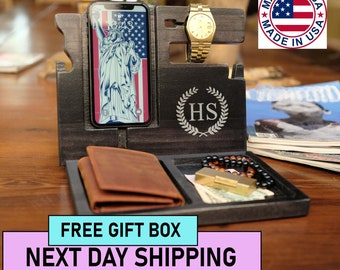 May include: A dark wood organizer with compartments for a phone, watch, wallet, and other items. The organizer has a personalized inscription "HS" and a small American flag with the text "Made in USA".