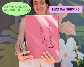May include: A pink leather portfolio with a floral design and the name "Celine" written in cursive. The portfolio is being held by a person.