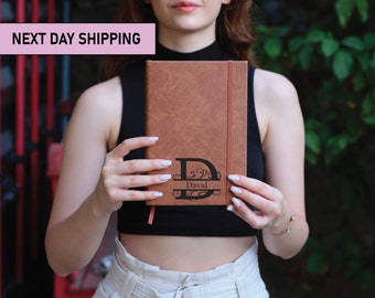 May include: A brown leather journal with a personalized monogram and the name "David" engraved on the front.