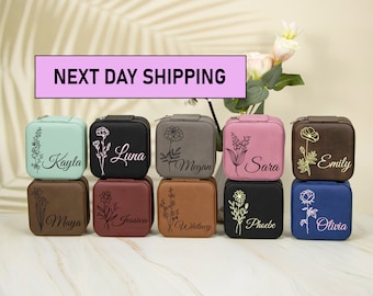 May include: Ten small square jewelry boxes with zipper closures. Each box is a different color and has a floral design and a name engraved on the front. The names are Kayla, Luna, Megan, Sara, Emily, Maya, Jessica, Whitney, Phoebe, and Olivia.