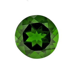 May include: A round, faceted green gemstone with a six-pointed star in the center.