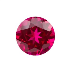 May include: A deep red star-shaped ruby gemstone with a faceted cut.