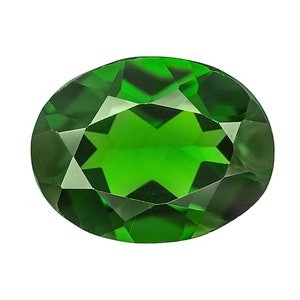 May include: A vibrant green oval-shaped gemstone with a faceted cut. The gem has a star-like pattern in the center.