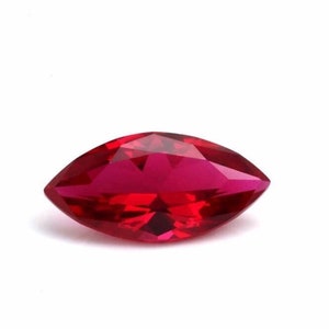 May include: A deep red marquise-shaped gemstone with a faceted cut.