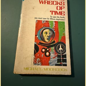 May include: Vintage paperback book titled "The Wrecks of Time" by Michael Moorcock. The cover features a retro sci-fi illustration of a person in a space suit. The book has a blue and white corner label that says "ace double".