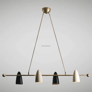 Op de afbeelding: Een hanglamp van messing en zwart met vier lampenkappen. Twee lampenkappen zijn wit en twee zijn zwart. De lamp wordt aan het plafond gehangen met een ketting.