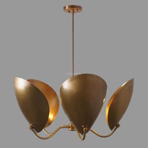 May include: A gold metal chandelier with four light fixtures. Each fixture is shaped like a half-opened flower bud.
