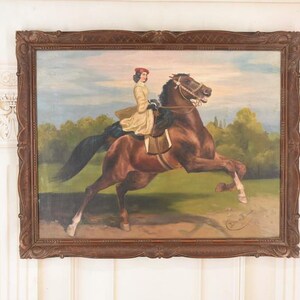 Pu&ograve; includere: Un dipinto ad olio antico in una cornice di legno scuro raffigura una persona che cavalca un cavallo marrone. Il cavaliere indossa un cappotto giallo e un cappello rosso. Il cavallo si impenna in un campo erboso con alberi sullo sfondo.