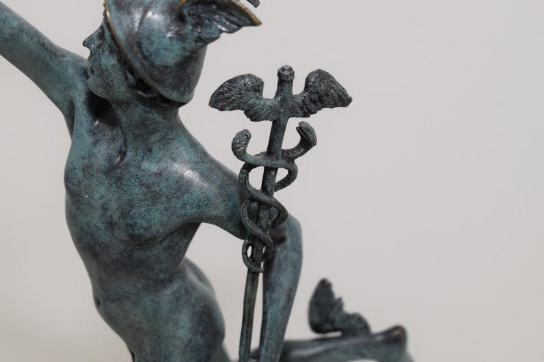 May include: A bronze statue of a mythological figure, possibly Hermes or Mercury, with a winged helmet and holding a staff with intertwined snakes. The statue has a verdigris patina, suggesting age or exposure to the elements. The figure is in a dynamic pose.