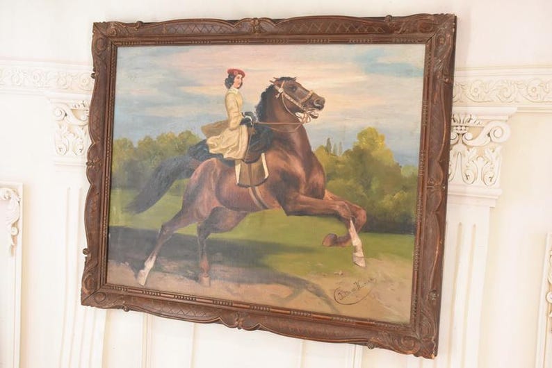 Pu&ograve; includere: Un dipinto a olio antico in una cornice di legno scuro raffigura una persona a cavallo di un cavallo marrone. Il cavaliere indossa un cappotto giallo e un cappello rosso. Il cavallo &egrave; in movimento, con le zampe anteriori sollevate. Lo sfondo mostra un campo verde e alberi.