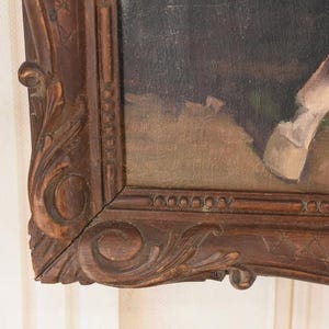 Pu&ograve; includere: Un angolo di un dipinto incorniciato con la gamba e lo zoccolo di un cavallo. Il dipinto &egrave; in una cornice di legno scuro e ornata con dettagli intagliati. L'opera d'arte raffigura un cavallo in un ambiente naturale, con toni tenui di marrone, beige e verde.