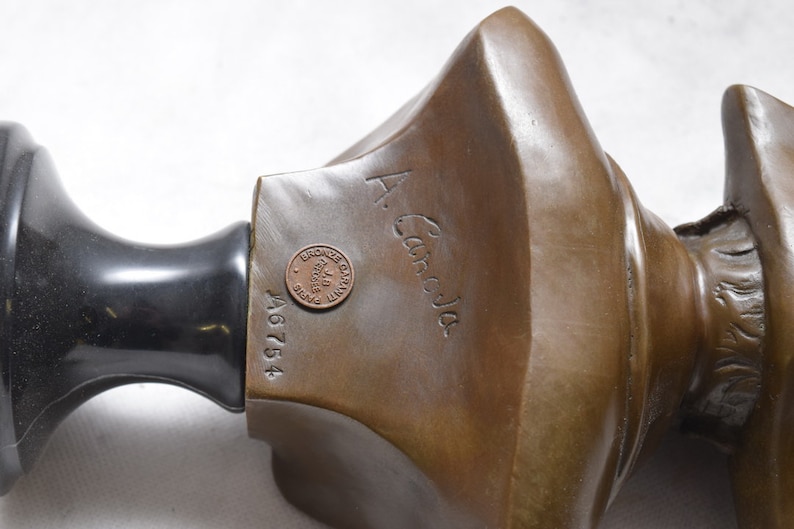 May include: Bronze sculpture bust with a black marble base. The bust is signed "A. Caroja" and has a bronze stamp with the inscription "Bronze d'Art Garantie Paris".