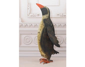 Op de afbeelding: Een groot metalen pinguïnbeeld met een zwart-wit geverfd ontwerp. De pinguïn heeft een rode snavel en oranje poten.