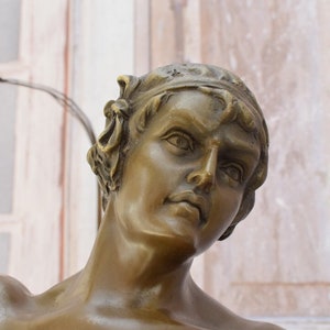 May include: Bronze sculpture of a man's head and shoulders. The man is looking up and to the right. His face is detailed and expressive. The sculpture is a classic example of Renaissance art.