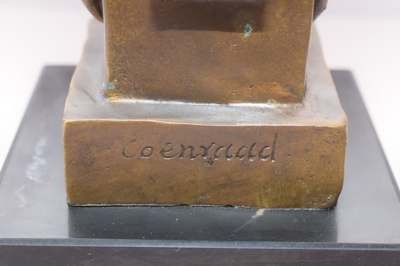 May include: Bronze sculpture of a seated figure with a signature on the base that reads "Coenraed".