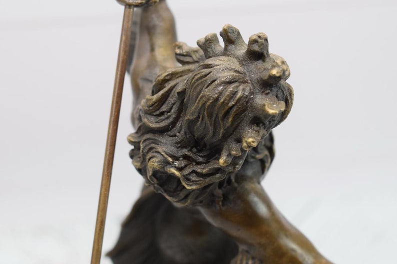 Puede incluir: Escultura de bronce de una figura mitol&oacute;gica con una lanza. La figura tiene una melena de le&oacute;n detallada y est&aacute; en una pose din&aacute;mica. La escultura es de color bronce antiguo c&aacute;lido.