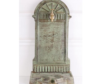 Fuente de pared de hierro fundido con grifo de latón: decoración de patio de estilo Art Nouveau.