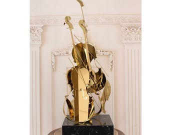Escultura de violín vintage de acero inoxidable dorado: arte musical hecho a mano sobre granito.