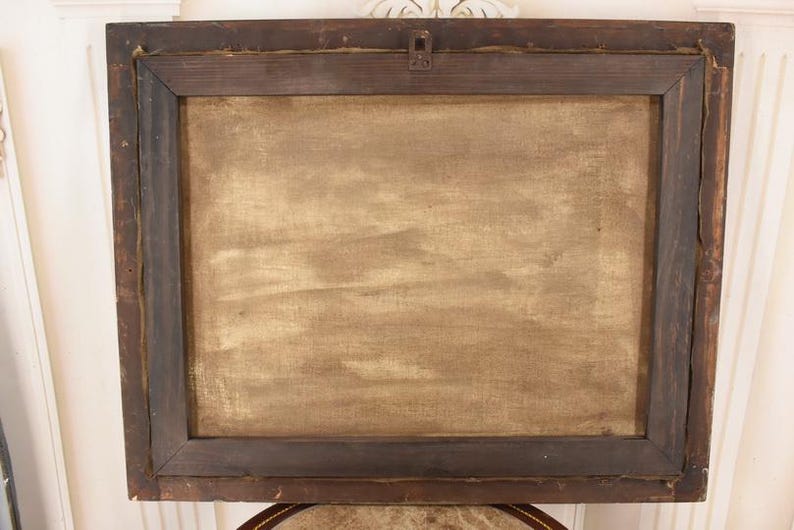 Pu&ograve; includere: Retro di un dipinto incorniciato. La cornice in legno marrone scuro racchiude una tela con una superficie strutturata marrone chiaro. Un gancio di metallo &egrave; fissato nella parte superiore centrale della cornice.