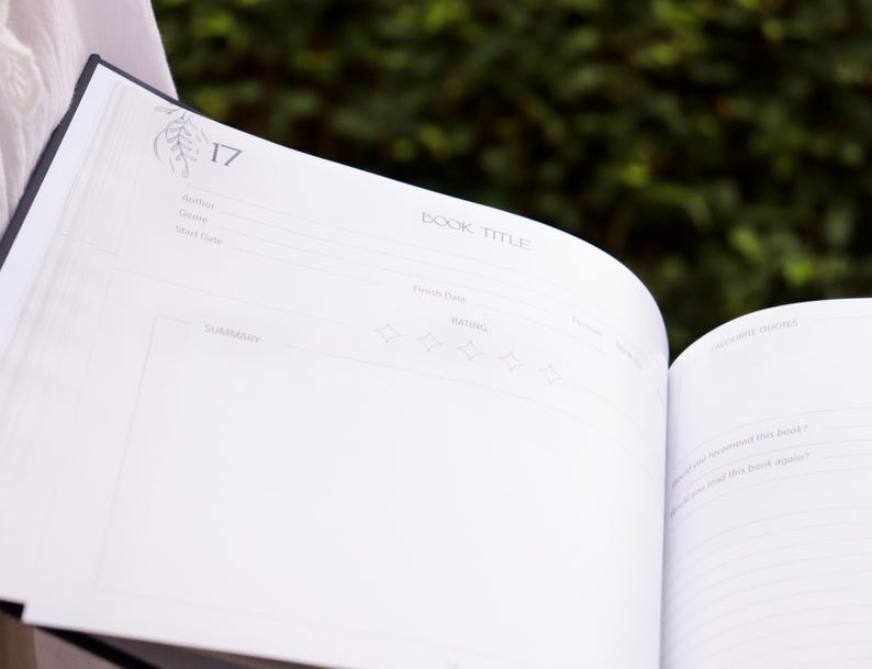 May include: A white book with a blue spine. The book is open to page 17, which has a section for recording book details, including author, genre, and a summary. The page also includes a rating section with five stars.