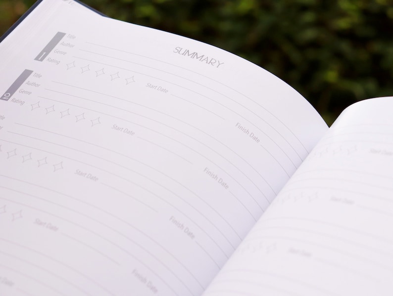 May include: A white book with a black cover and the word "SUMMARY" printed on the top of the page. The book has a section for recording book titles, authors, genres, and ratings.