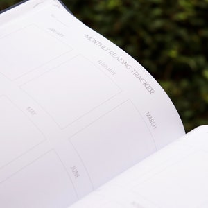 May include: A white monthly reading tracker with a grid of six squares. Each square is labeled with a month of the year: January, February, March, April, May, and June.