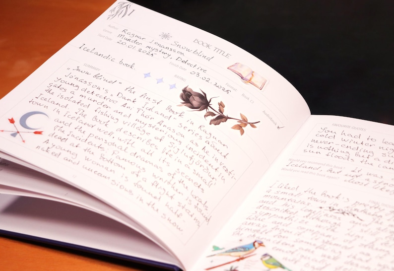May include: Open book with a black rose illustration and handwritten text. The text includes the book title "Snow Blind" and the author's name "Ragnar Jonasson".