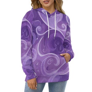 Peut inclure: Un sweat à capuche violet avec un motif abstrait tourbillonnant dans des tons de violet et de blanc. Le sweat à capuche a une capuche à cordon, une poche avant et des manches longues. Le motif présente des lignes et des formes courbes.