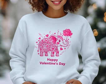 Könnte beinhalten: Weißes Sweatshirt mit einem rosa Elefanten-Design, der herzförmige Ballons hält. Der Elefant ist mit Herzmustern verziert. Der Text "Happy Valentine's Day" ist darunter gedruckt.