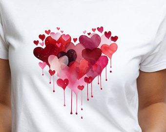 Könnte beinhalten: Weißes T-Shirt mit einem Aquarell-Herz-Design. Das Herz besteht aus verschiedenen Rot- und Rosatönen, wobei einige heruntertropfen. Ein romantisches und künstlerisches Design.