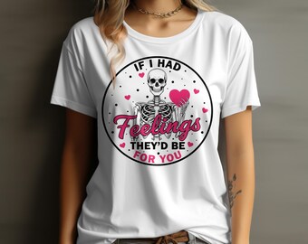 Könnte beinhalten: Weißes T-Shirt mit einem kreisförmigen Design, das ein Skelett mit einem rosa Herzen zeigt. Der Text lautet "IF I HAD Feelings THEY'D BE FOR YOU" in Rosa und Weiß. Kleine rosa Herzen und schwarze Punkte umgeben die Grafik.