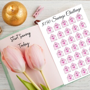May include: A printable savings challenge sheet with pink envelopes and hearts. The sheet has a title that reads "$150 Savings Challenge". The sheet is on a white background.