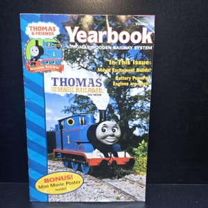 May include: A Thomas & Friends Yearbook, Volume VI, featuring Thomas the Tank Engine from "Thomas and the Magic Railroad." The cover shows a blue train with the number 1, steam, and the text "BONUS! Mini Movie Poster inside!"