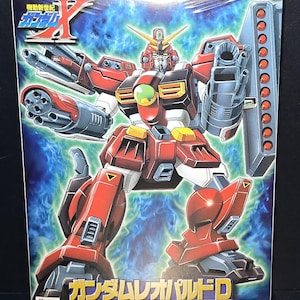 May include: A rectangular model kit box featuring the Mobile Suit GT-9600-D Gundam Leopard Destroy. The box art displays the red, white, and dark gray robot with multiple mounted cannons and missile launchers against a blue energy background.