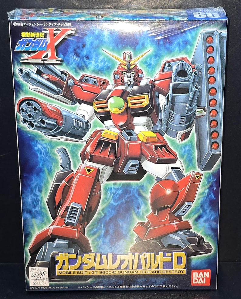 May include: A rectangular model kit box featuring the Mobile Suit GT-9600-D Gundam Leopard Destroy. The box art displays the red, white, and dark gray robot with multiple mounted cannons and missile launchers against a blue energy background.