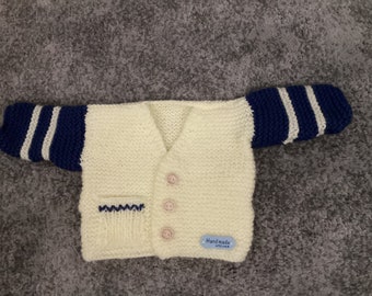 Hand knitted baby cardigans. Cream and blue double knitting wool.