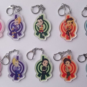 Può includere: Set di dieci portachiavi colorati con personaggi dei cartoni animati con un design circolare. Ogni portachiavi ha un personaggio e uno schema di colori diverso.