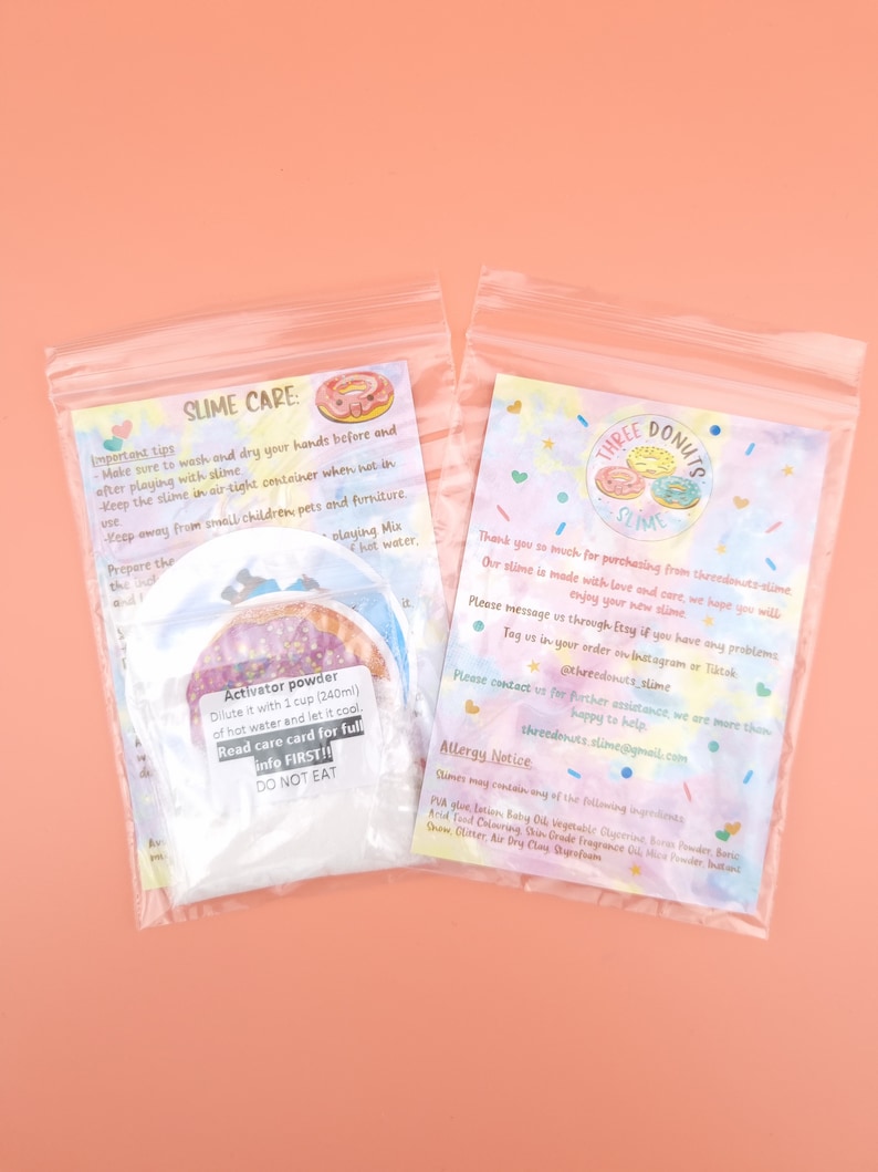 May include: Two clear plastic bags with colorful labels. The labels contain instructions for slime care, including how to activate the powder and an allergy notice. The labels also feature a logo with three donuts and the text "Three Donuts Slime".