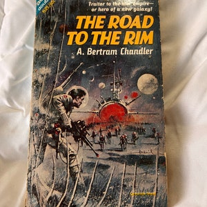 Może przedstawiać: Biały ceramiczny kubek z czarnym uchwytem i napisem "But First, Coffee" pogrubioną, czarną czcionką. Kubek jest umieszczony na neutralnym tle, podkreślając jego prosty design.