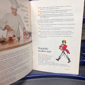 May include: A vintage magazine spread featuring a chef and a bottle of Johnnie Walker Red. The text includes cooking tips and a section on "Hospitality modern style." The page has a retro aesthetic.