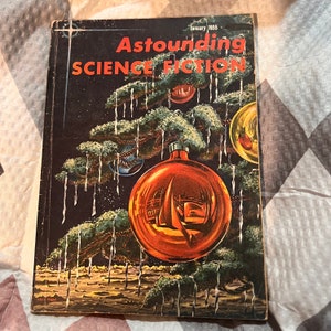 Peut inclure: Numéro de janvier 1955 du magazine vintage "Astounding SCIENCE FICTION". La couverture présente un sapin de Noël avec des boules, dont une grande boule orange reflétant un voilier. Le magazine est en bon état.
