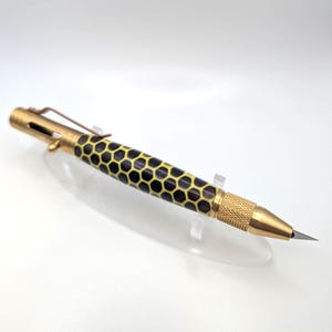 May include: A white ceramic mug with a black handle and the text "But First, Coffee" in a bold, black font. The mug sits on a white surface, showcasing its clean design.