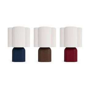 May include: Three table lamps featuring white, vertically ribbed cylindrical shades. Each lamp has a solid, rounded base in a different color: one deep navy blue, one medium brown, and one dark red. The lamps stand upright and separate.
