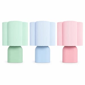 May include: Three table lamps in pastel colors: mint green, light blue, and soft pink. Each lamp features a smooth, rounded base and a cylindrical, vertically ribbed shade that creates a textured, pleated appearance across the surface.