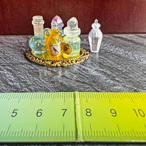 Miniatuurset toverdrankflessen op een gouden plaat