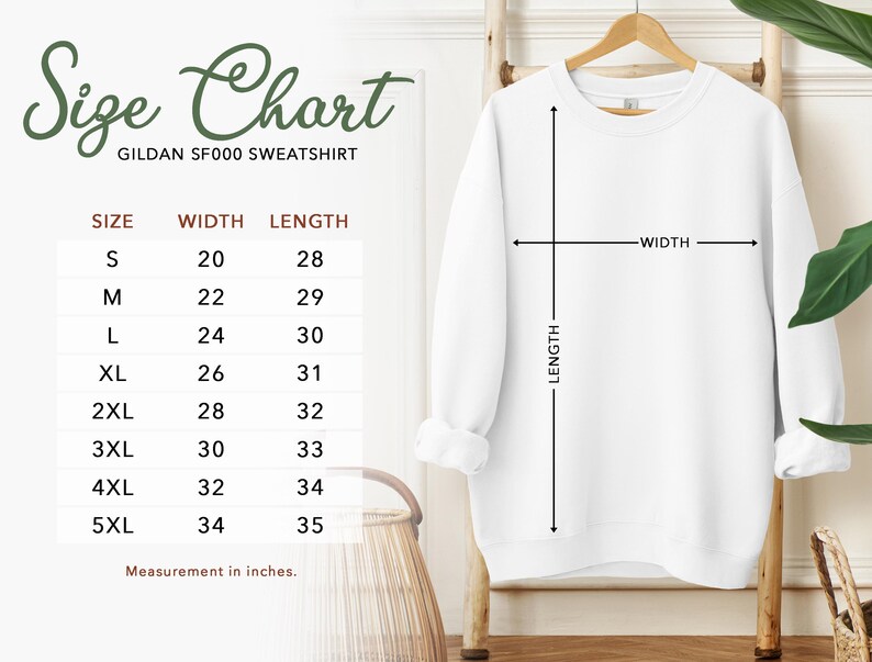 a size chart for a GILAN SF500 sweatshirt, with measurements for different sizes ranging from S to M. The chart is accompanied by a wooden hanger and a plant, creating a casual and relaxed setting.