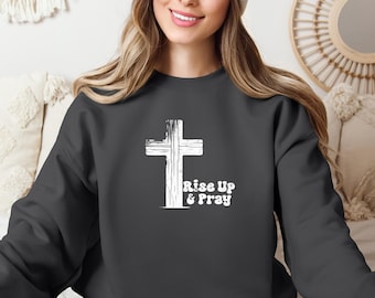 May include: A dark gray sweatshirt with a white distressed cross and the text "Rise Up & Pray" printed on the front.