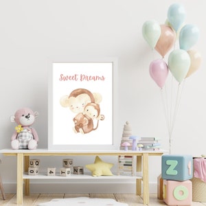 May include: A white framed print featuring a watercolour illustration of two monkeys. The larger monkey is holding a smaller monkey. The text "Sweet Dreams" is written in pink above the monkeys.